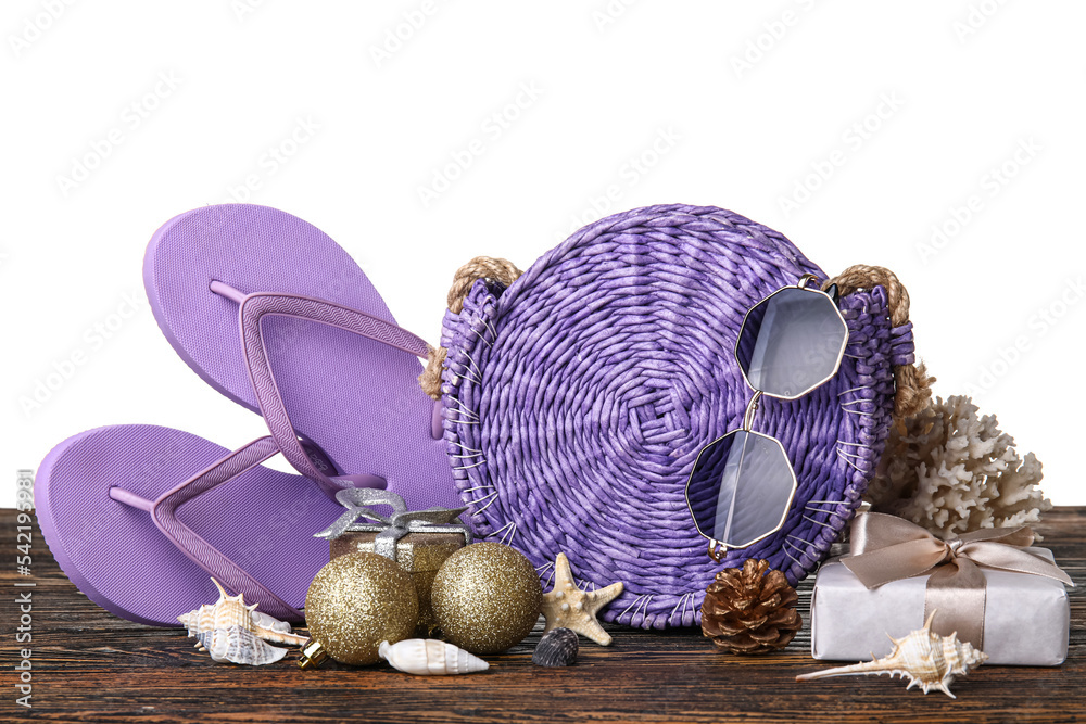 Travel accessories with Christmas decor and gifts on table against white background