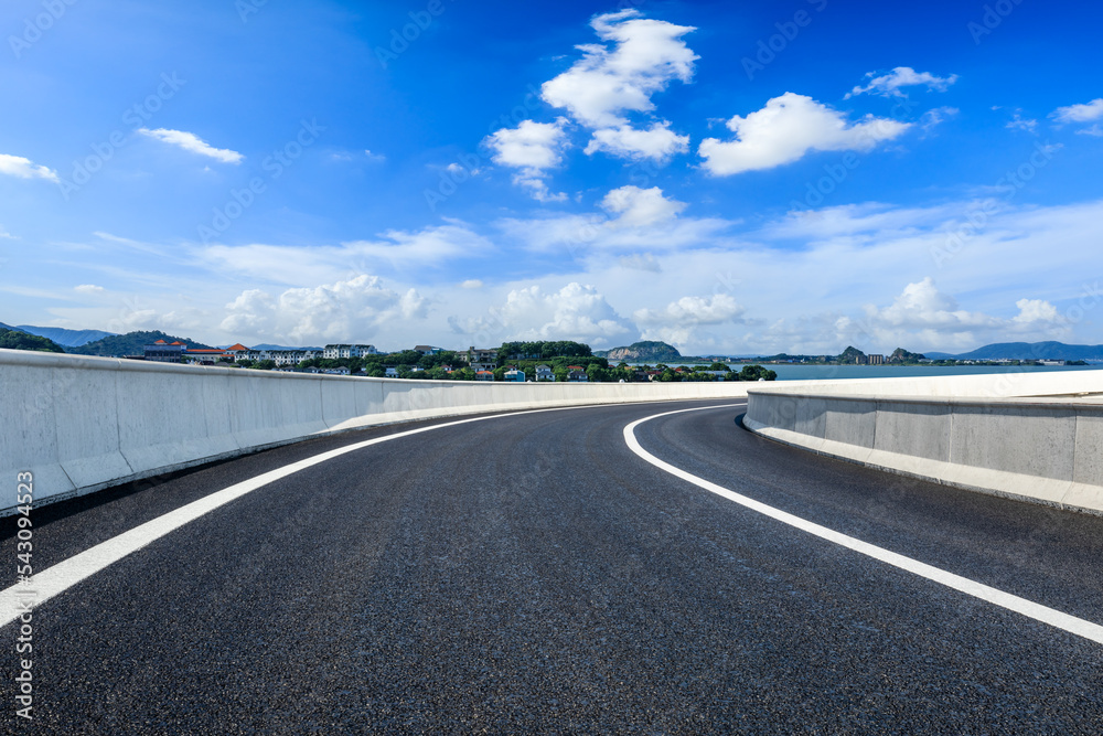 Asphalt road and river with mountain nature landscape under blue sky