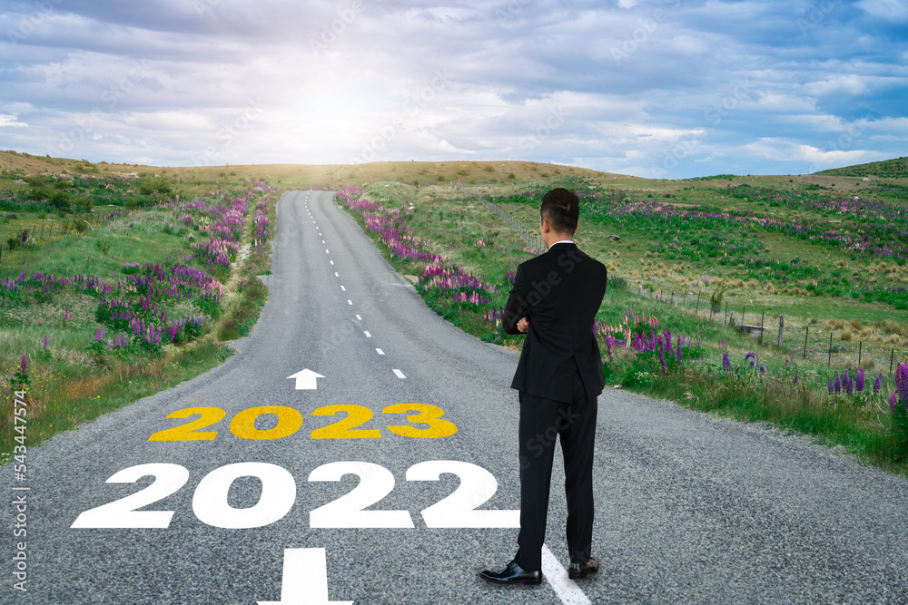 The 2023 New Year journey and future vision concept . Businessman traveling on highway road leading 