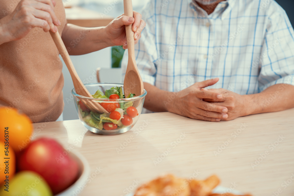 满足于在厨房里一起烹饪面包、蔬菜和水果的老年夫妇