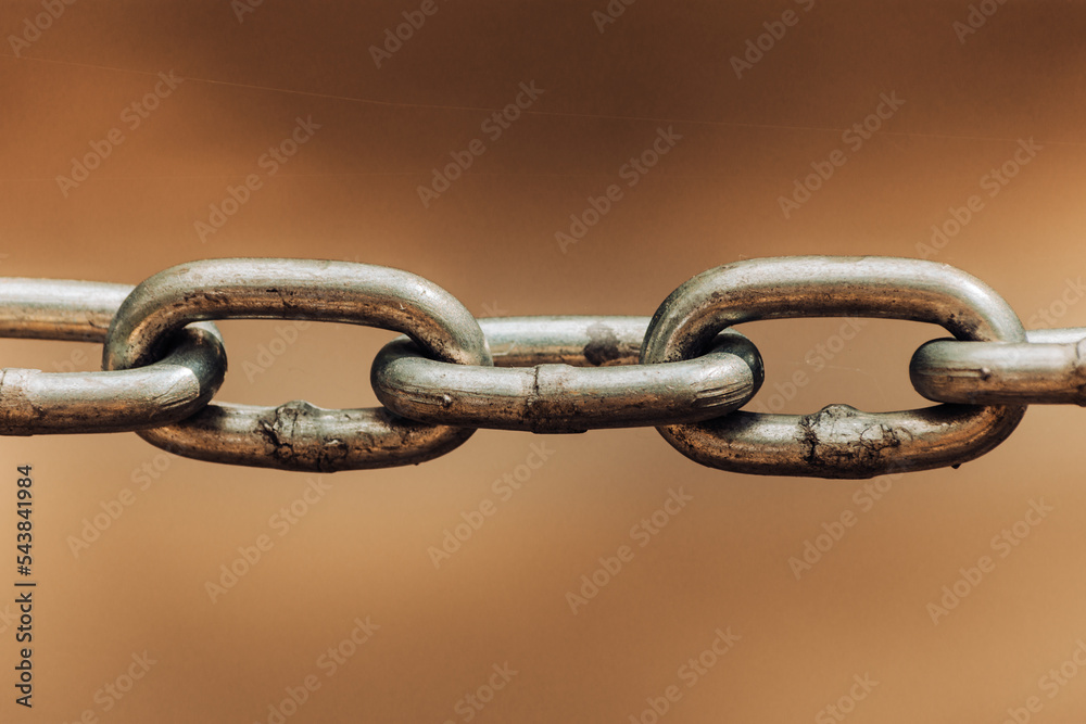 Close up chain links on sepia colored backdrop as old connection concept