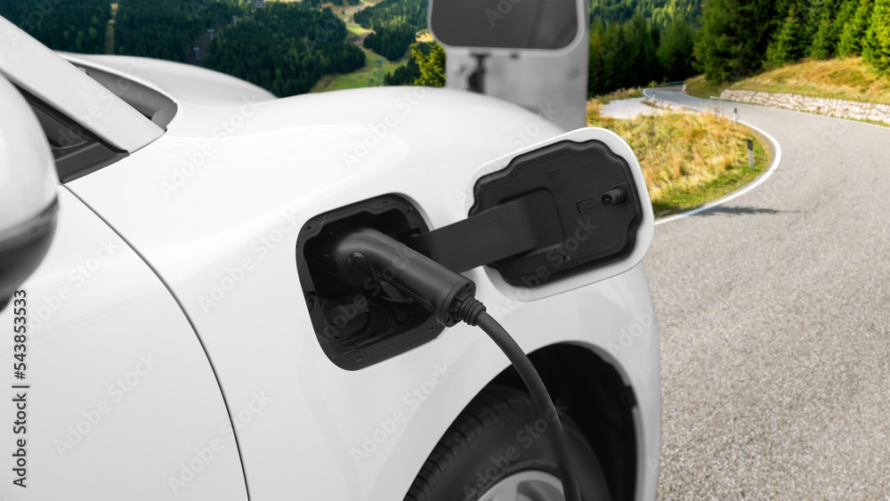 Progressive concept for environmental awareness by electric car at the charging station on the hill 