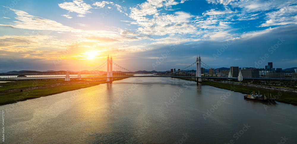 中国浙江舟山，日落时分，美丽的桥梁和河流与城市天际线交织在一起。