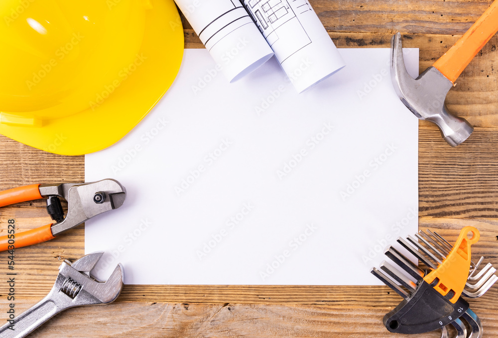 Hard hats and drawing tools on a wooden table