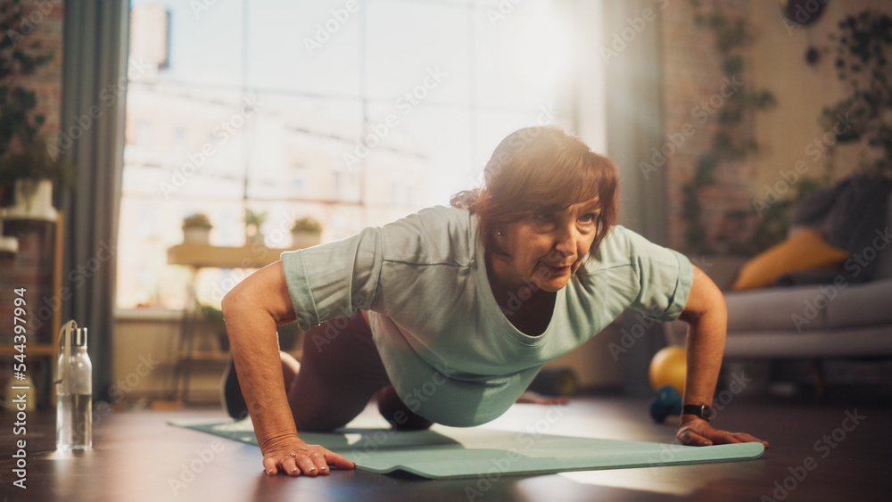 Happy Fit Senior Woman Training on a Yoga Mat, Doing Burpees Exercises During Morning Workout at Hom