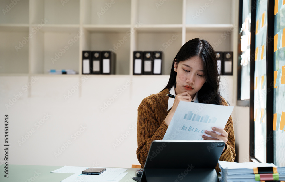 专注的亚洲商务女士分析文件的肖像