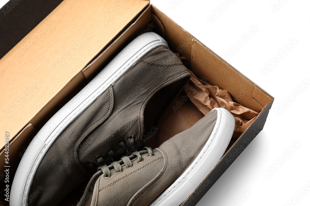 Cardboard box with male sneakers on white background