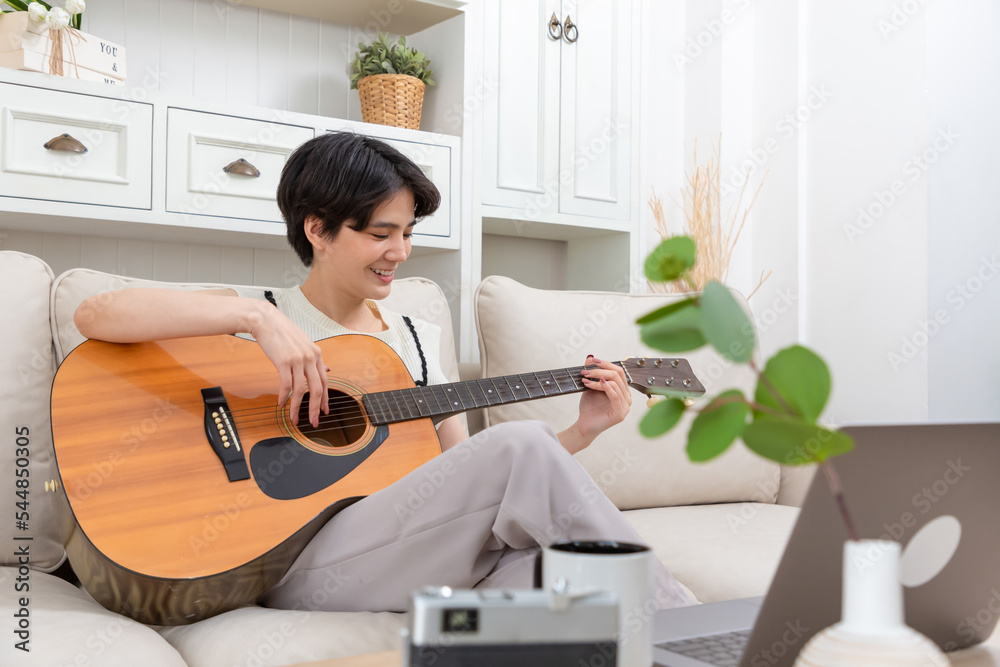 在家弹原声吉他的亚洲女人，年轻的亚洲音乐家女孩生活