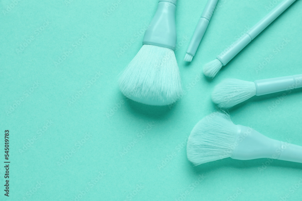 Makeup brushes on mint background