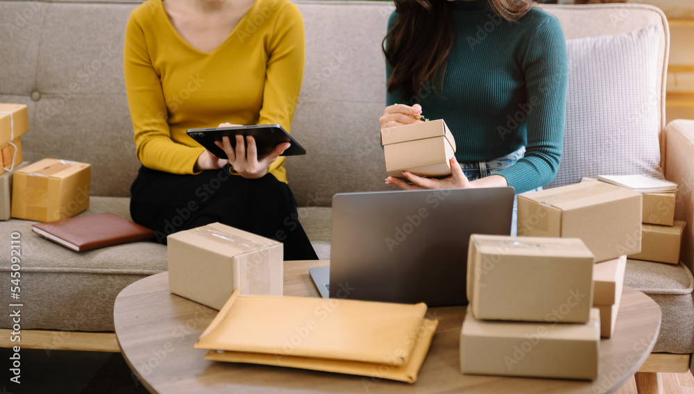 young Asian wman and women at office of their business online shopping.In home office.