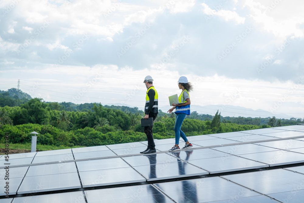 Technician wearing safety harness belt during installing the solar panels on roof structure of build