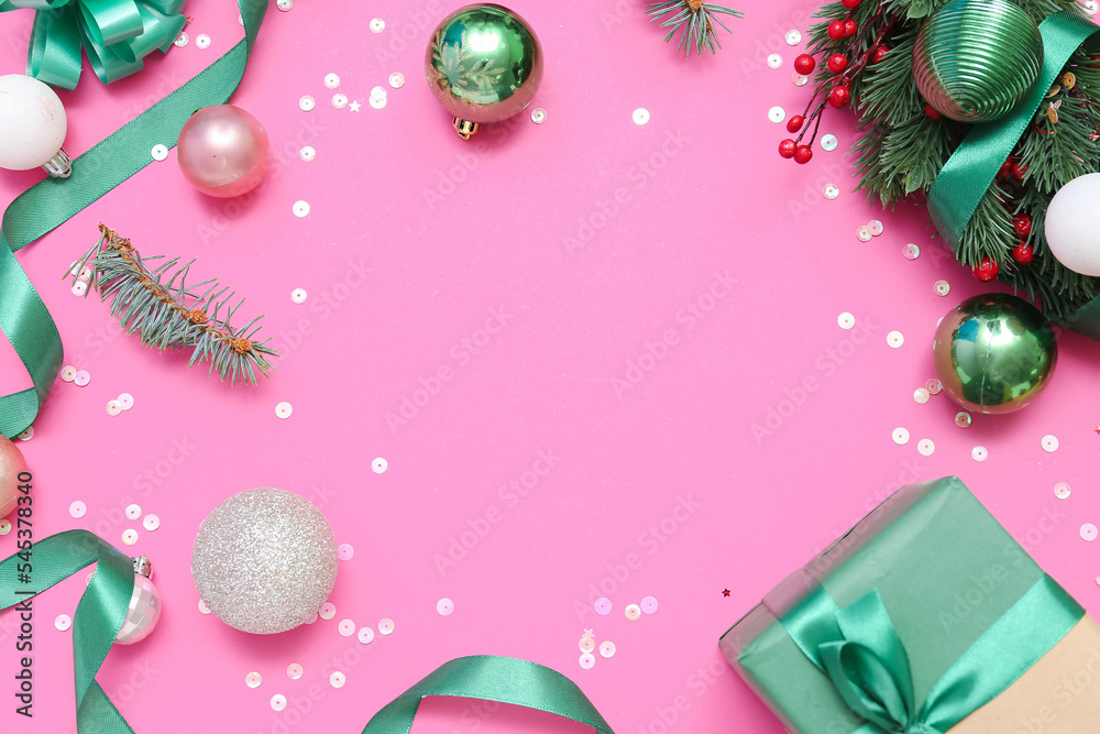 Frame made of Christmas balls, gift, wreath and ribbon on pink background, closeup