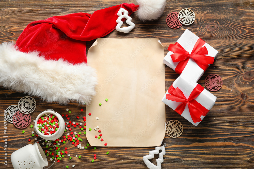 Composition with blank letter to Santa, hat, Christmas gifts and decorations on wooden background