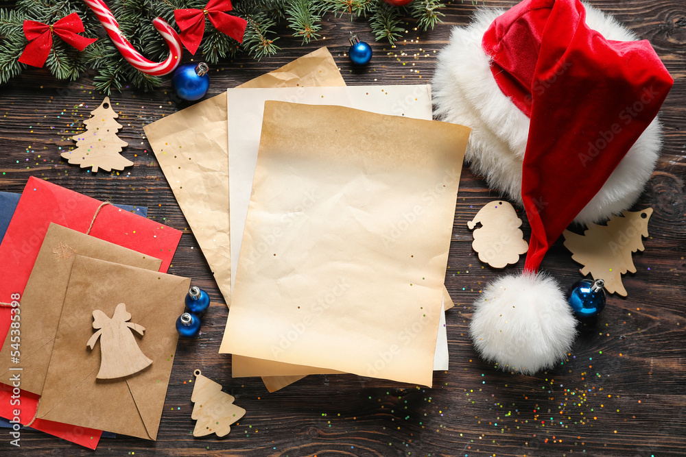 Composition with blank letter to Santa, envelopes and Christmas decor on wooden background