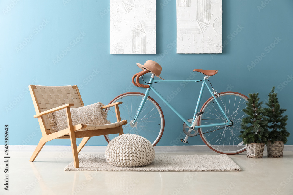 Interior of living room with bicycle, armchair and small fir trees