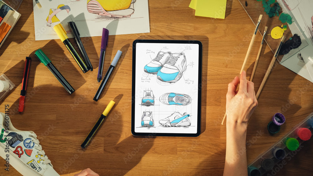 Top View Of Female Footwear Designer Drawing Sketch of Sneakers on Tablet Computer from Upcoming Col