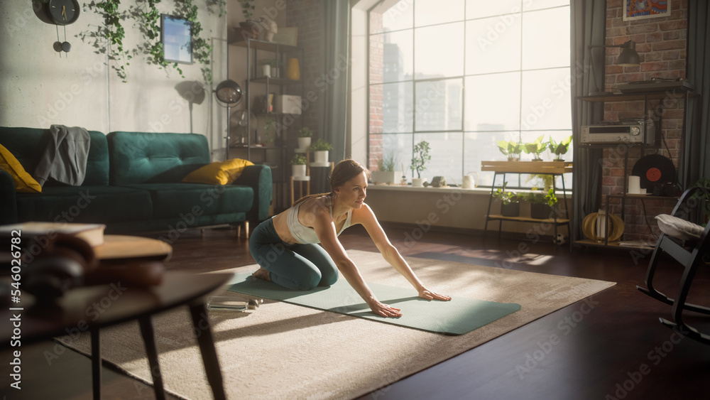 Young Beautiful Female Exercising, Stretching and Practising Yoga in the Morning in Her Bright Sunny