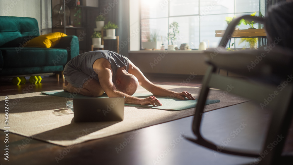 Young Handsome Male Exercising, Stretching and Practising Comlex Yoga Positions in the Morning in Hi