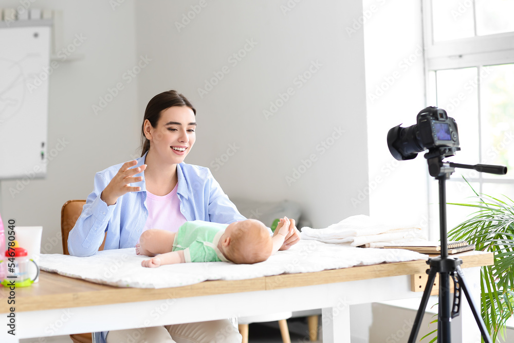 带着小婴儿的年轻女子在家录制视频课程