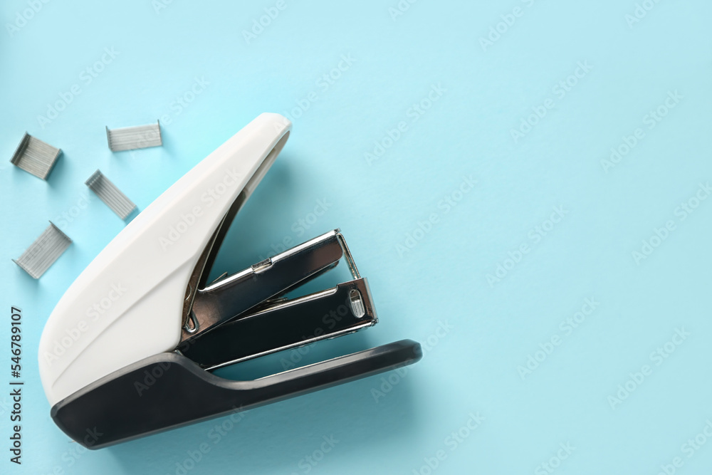 Office stapler with staples on color background