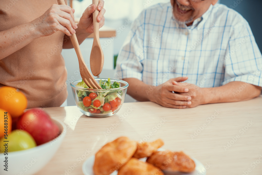 满足的老年夫妇，他们很乐意在厨房里一起烹饪面包、蔬菜和水果