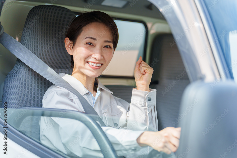 運転席でガッツポーズをする女性