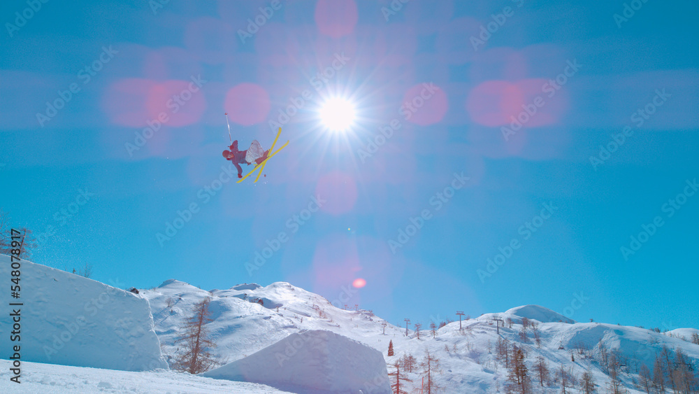 低角度视角：极限自由式滑雪运动员在大空中跳跃后在空中飞行