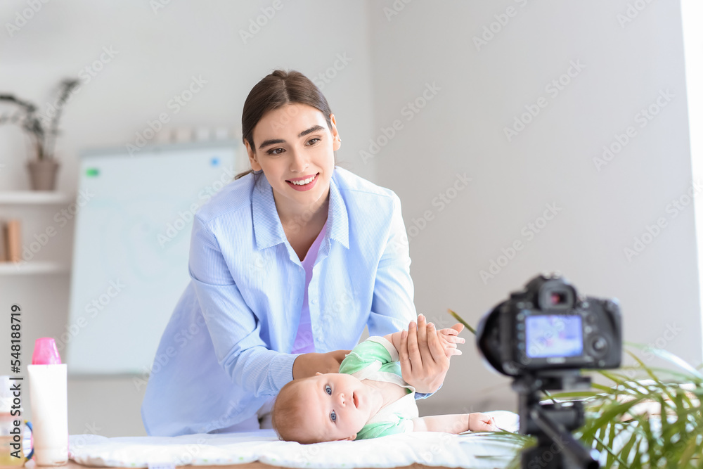 带着小婴儿的年轻女子在家录制视频课程