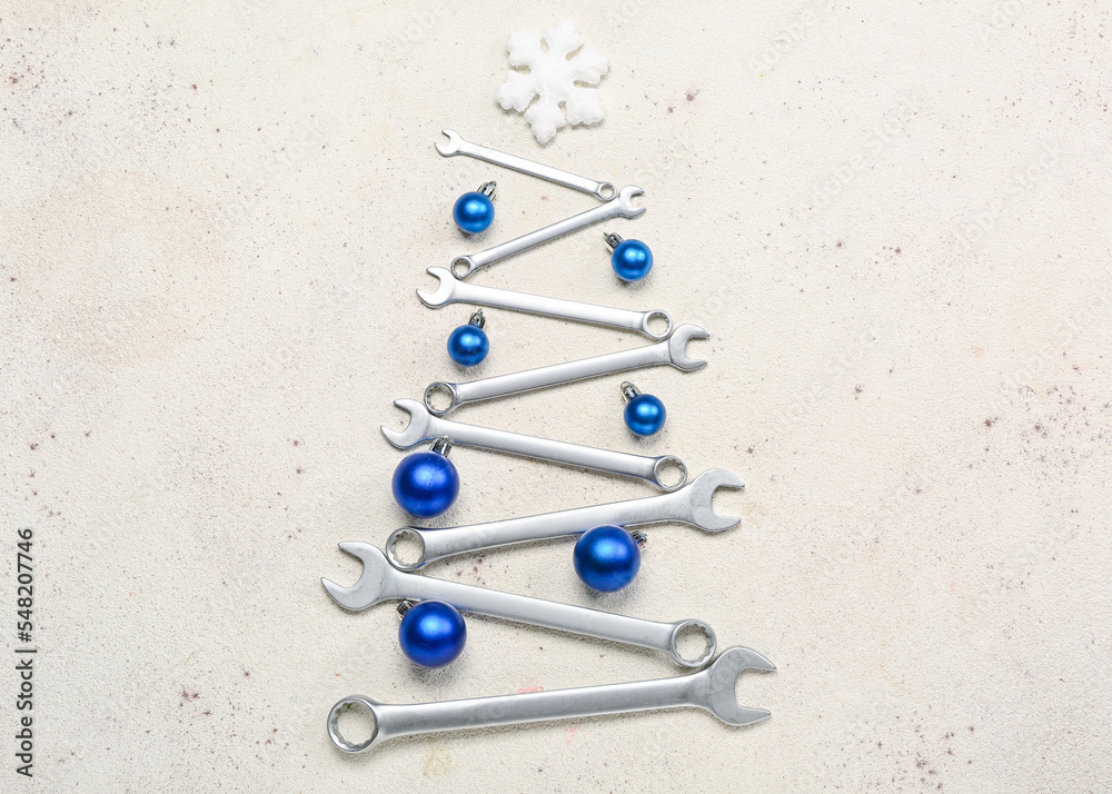 Christmas tree made of balls and wrenches on light background