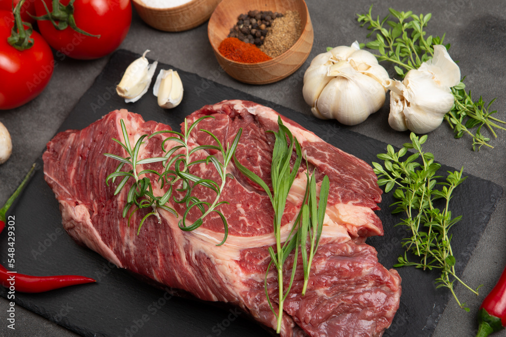 Raw beef steak on concrete table top. Healthy food concept. beef cut and spices for cooking bbq sauc