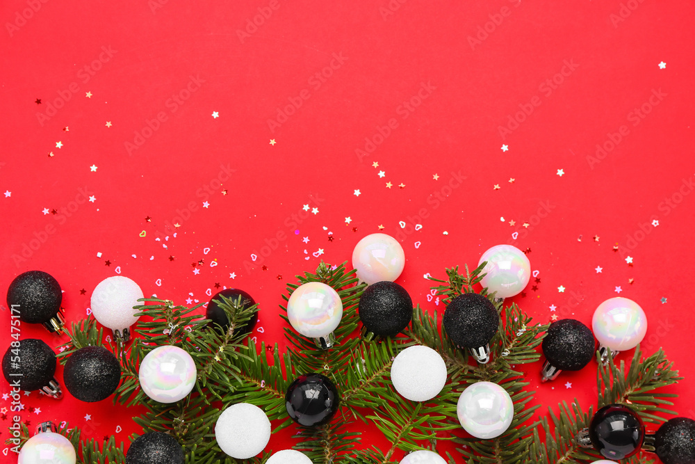 Composition with fir branches, Christmas balls and sequins on red background