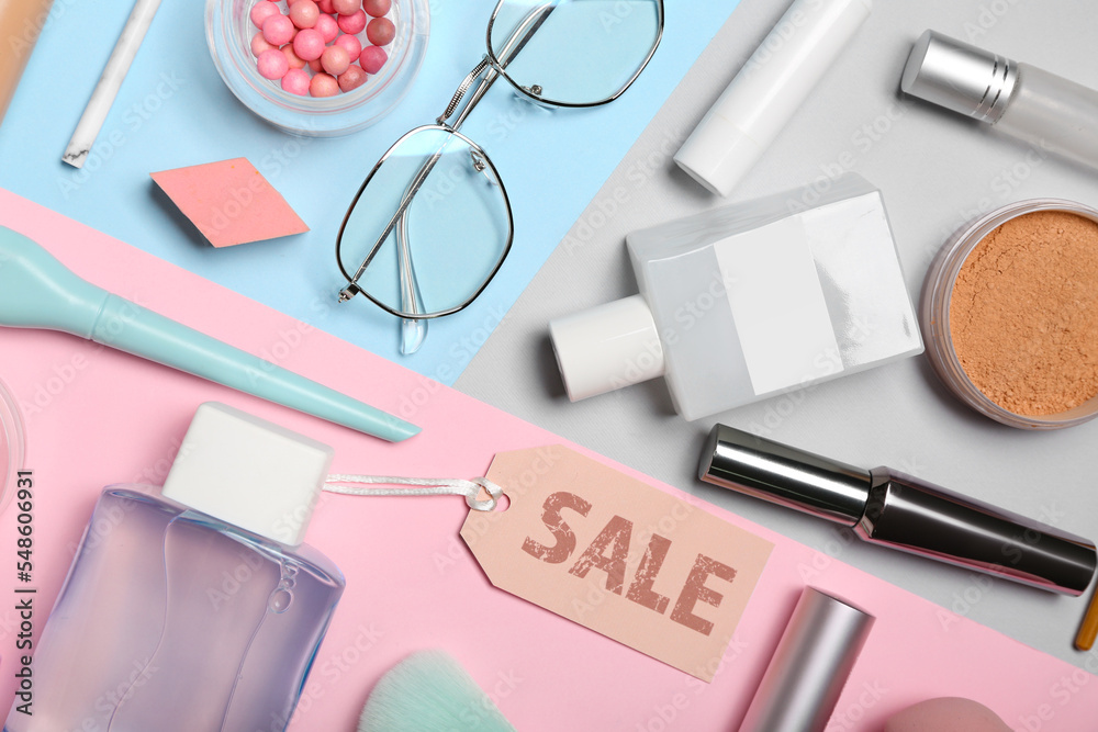 Cosmetics, accessories and sale tag on color background