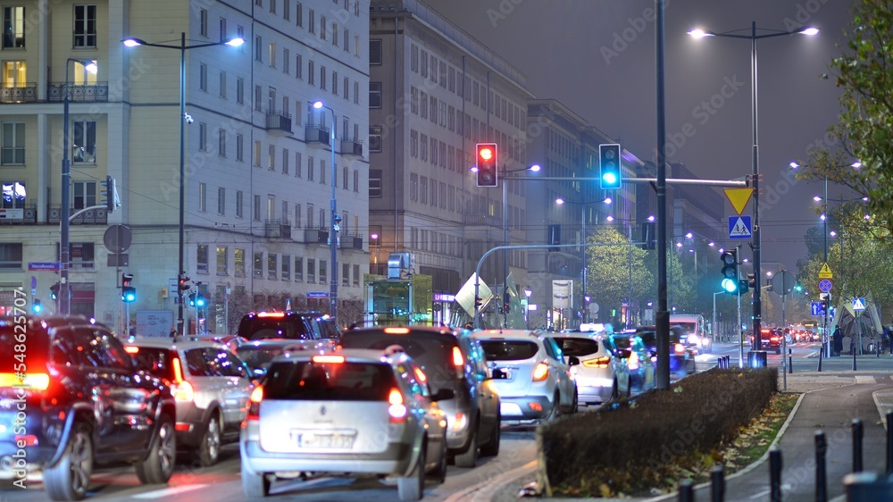 市中心的晚间城市生活。街上的汽车。夜晚的城市路灯。