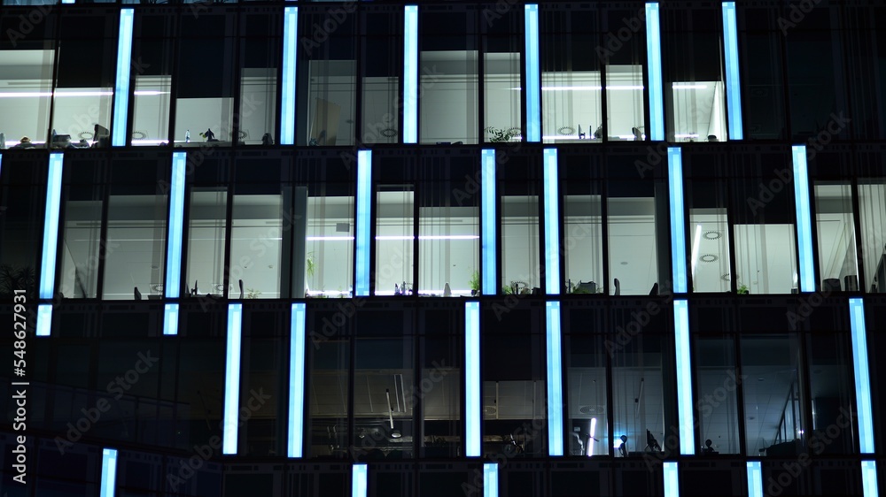 Modern office building in city at the night. View on illuminated offices of a corporate building. Bl