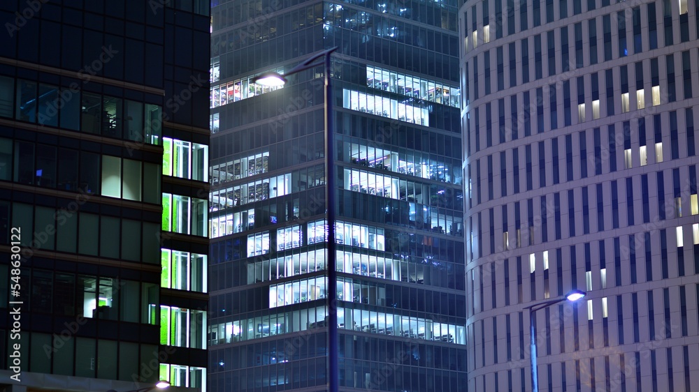 Modern office building in city at the night. View on illuminated offices of a corporate building. Bl