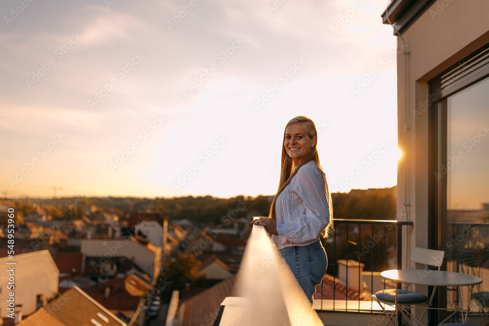 Smiling woman posing for the camera, being on the terrace.