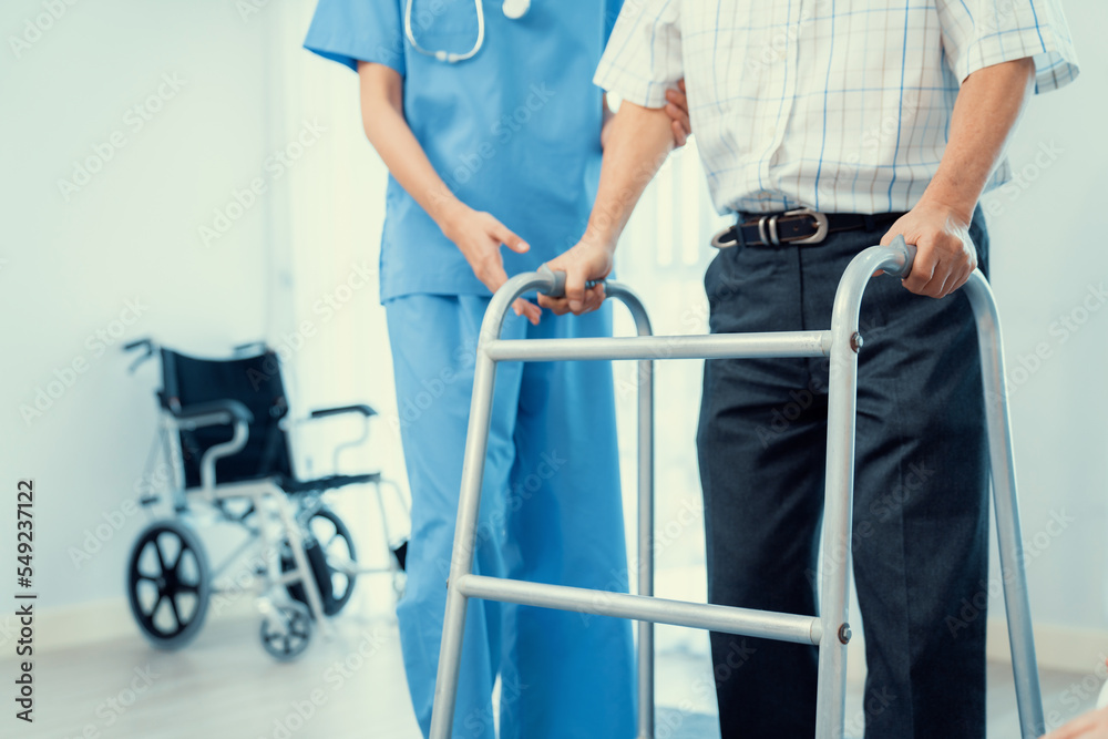 Physiotherapist assists contented senior man on folding walker. Recuperation for elderly, seniors ca