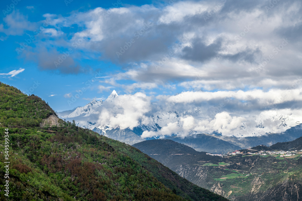 Meri snow mountain and town landscape in Deqen prefecture Yunnan province, China.	 