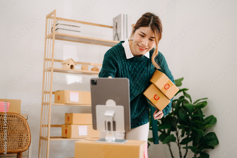 .Young woman holding a smartphone showing payment success and credit card with yellow parcel box as 