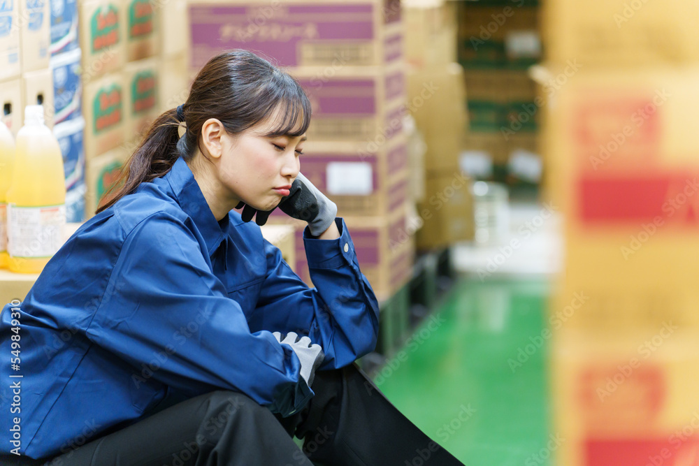 倉庫で休憩する女性作業員