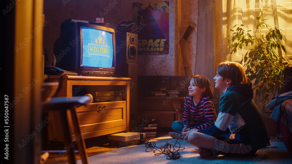 Nostalgic Happy Childhood Concept: Young Brother and Sister Playing Old-School Arcade Video Game on 