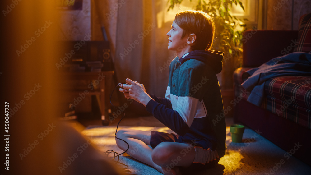 Handsome Child Playing Video Game on a Console at Home in His Room with Eighties Interior. Young Boy