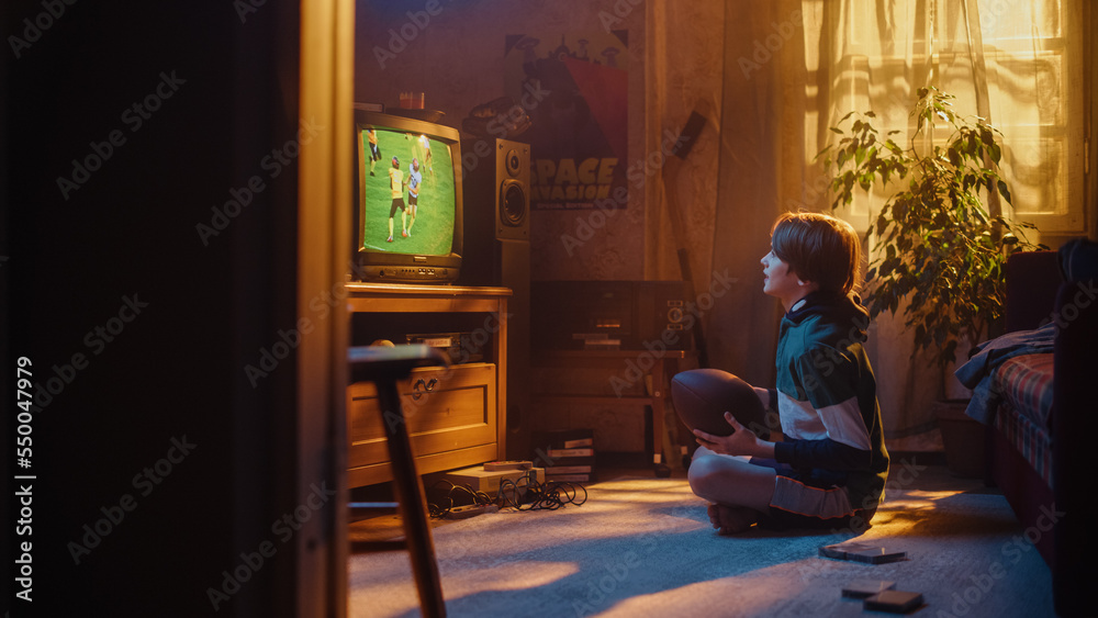 Young Sports Fan Watches American Football Match on Retro TV in His Room with Dated Interior. Boy Su