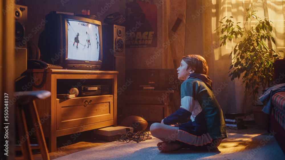 Nostalgic Retro Childhood Concept. Young Boy Watches Hockey Match on TV in His Room with Dated Inter