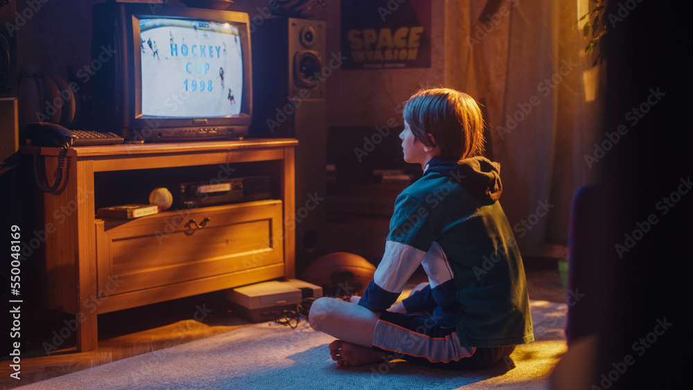 Nostalgic Retro Childhood Concept. Young Boy Watches Hockey Match on TV in His Room with Dated Inter