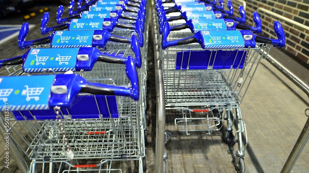 Row of shopping carts outside market in night.