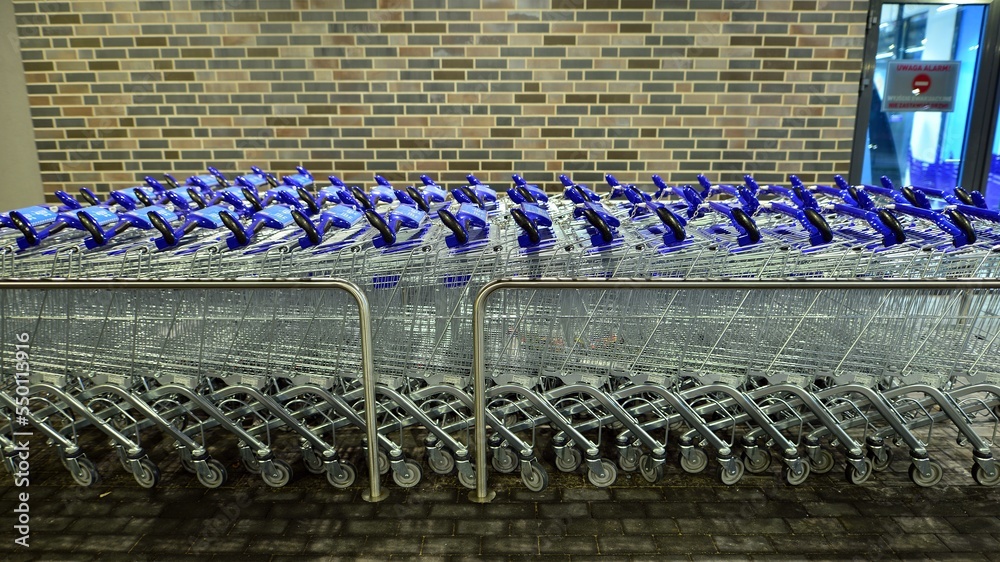 Row of shopping carts outside market in night.