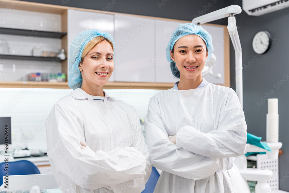 Portrait of Two young beautiful dentist stand at dental health clinic. 