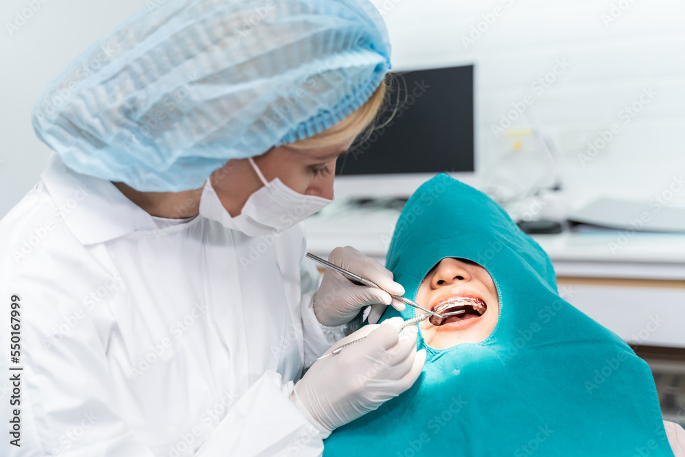 Orthodontist doctor examine tooth to woman patient at dental clinic. 