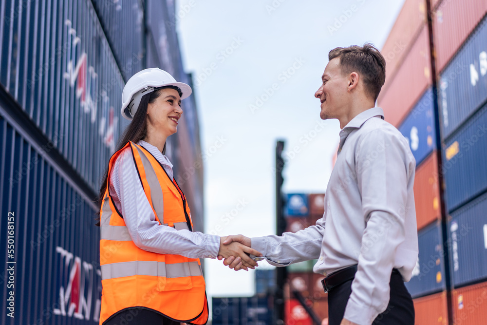 Caucasian businesswoman and businessman worker work in container port. 